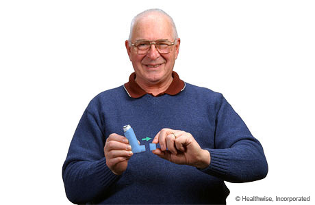A man removing the cap from an inhaler