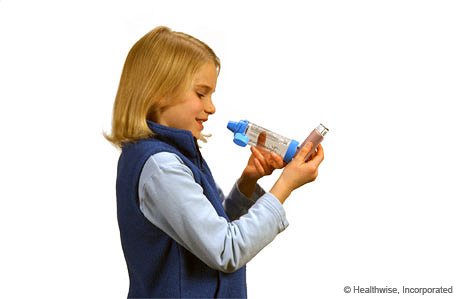 A child holding the inhaler upright